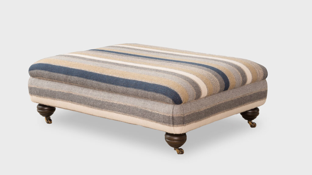 John Sankey Fender Striped Ottoman with Blackened Oak feet fitted with antique brass castors - top