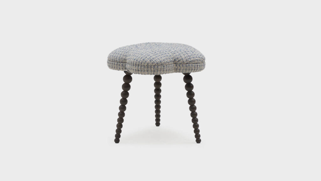 John Sankey floral footstool with dark bobbin legs covered in a slubby texture - front