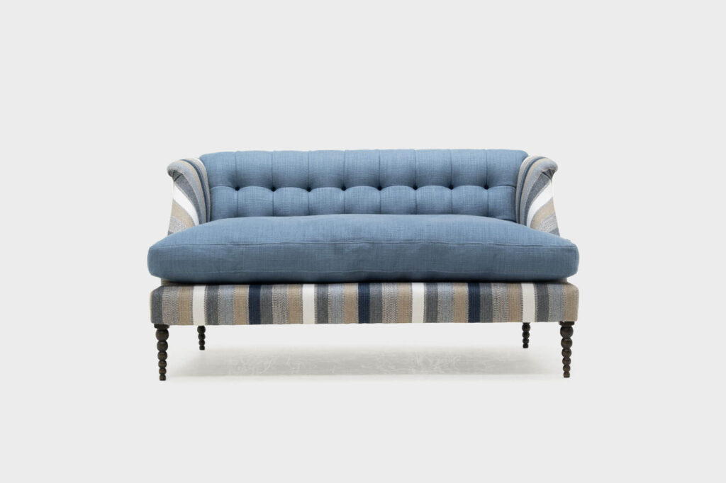 low boodle sofa covered in a wool navy stripe with bobbin legs - front