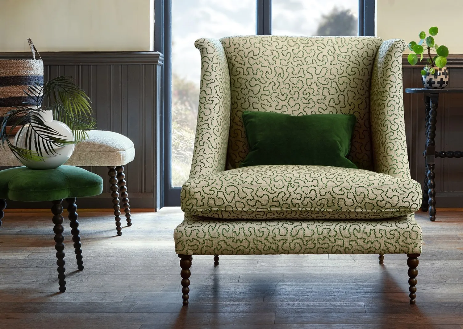 A patterned John Sankey wing chair with turned wooden legs